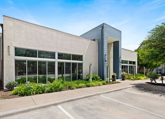 the exterior of a building with large windows and a sidewalk