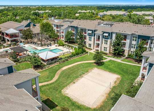 an aerial view of an apartment complex with a tennis court and a pool