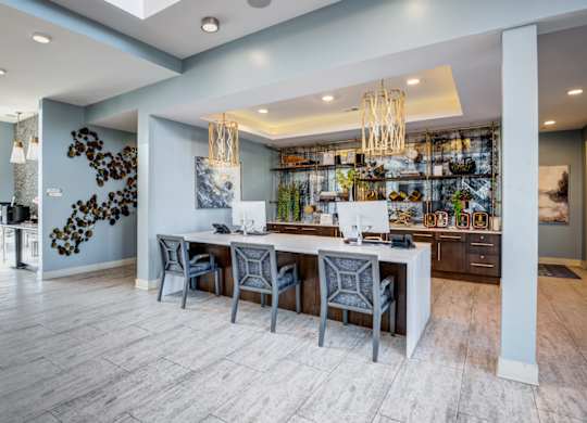 A modern kitchen with a long island and chairs.