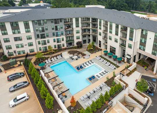 an aerial view of a large swimming pool in front of a building