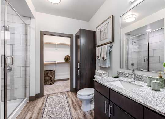 A bathroom with a toilet, sink, and a mirror.