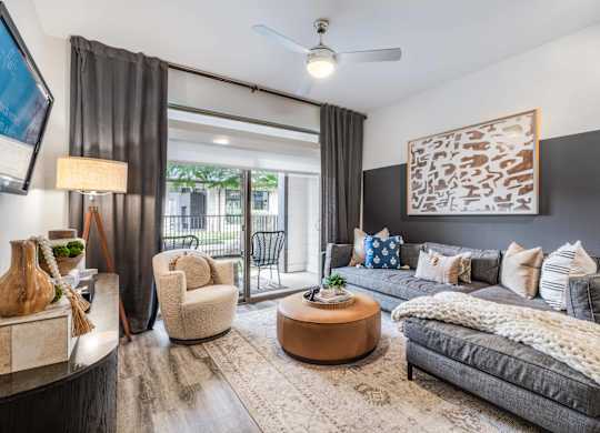 A modern living room with a grey couch, a coffee table, and a large painting on the wall.