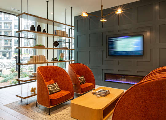 a living room with two orange chairs and a television