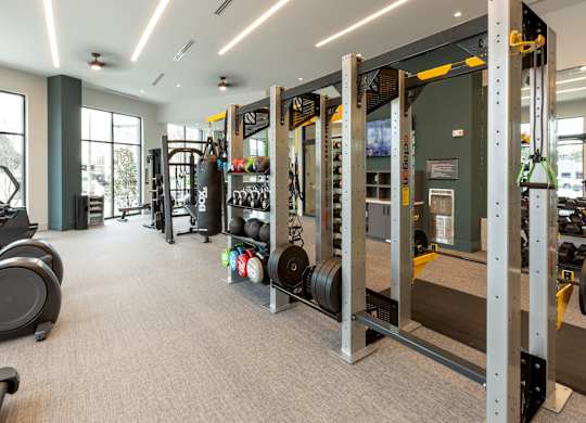 a gym with weights and other equipment in a building with windows