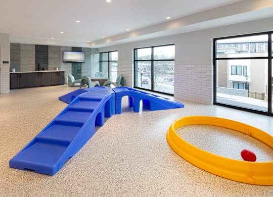 a childrens play room with a yellow tub and blue benches