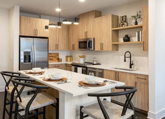 a kitchen with a large island with chairs and a table