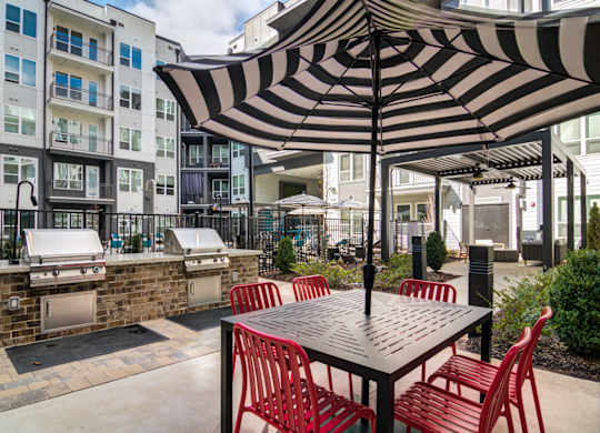 a patio with an umbrella and a table with chairs