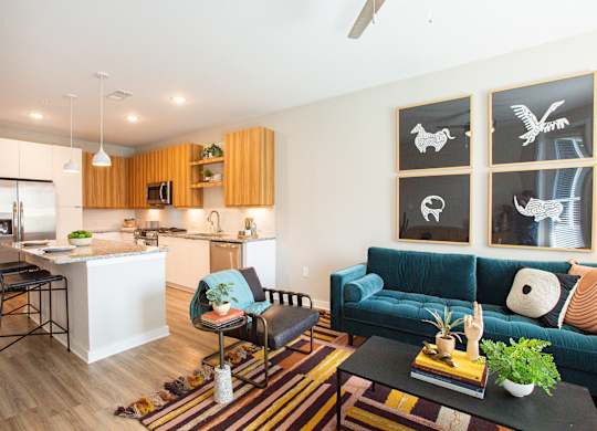 a living room with a blue couch and a kitchen with an island