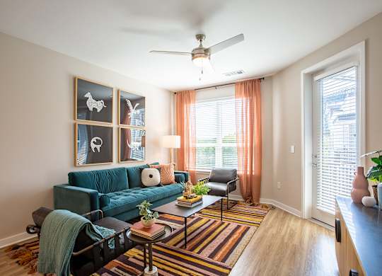 a living room with a blue couch and a ceiling fan