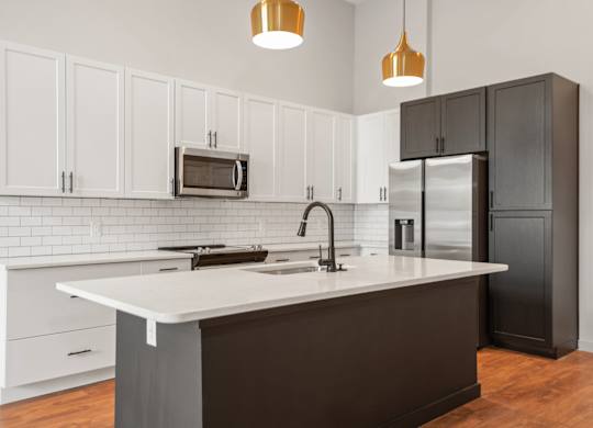 A kitchen with white cabinets and a black refrigerator.