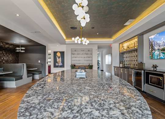 A modern kitchen with a marble island in the center.