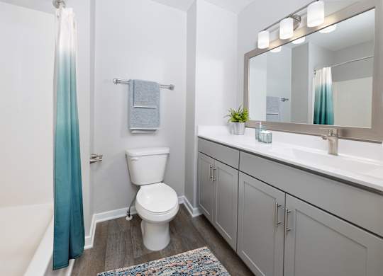 A white toilet sits in a bathroom next to a white sink.
