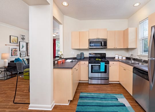 A kitchen with a refrigerator, oven, and microwave.