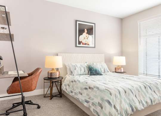 a bedroom with a bed and a desk with a chair