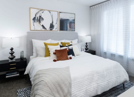 a bedroom with a large bed with white sheets and pillows