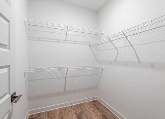 A white closet with shelves and a door.