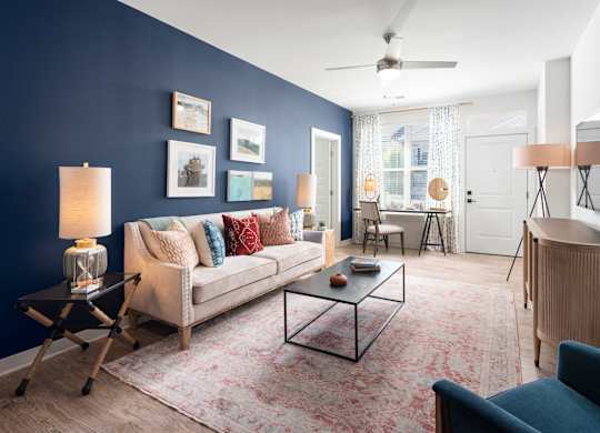 A living room with a couch, a coffee table, and a lamp.
