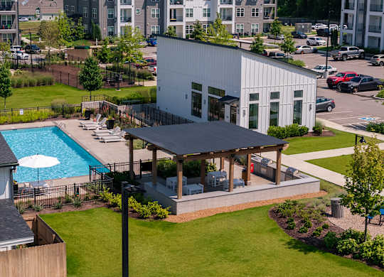 A white building with a pool in the backyard.