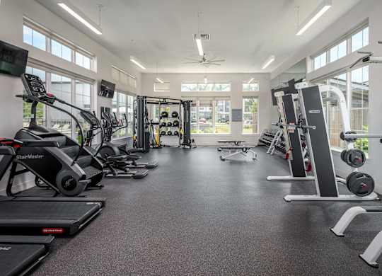 A spacious gym with treadmills, elliptical machines, and weightlifting equipment.