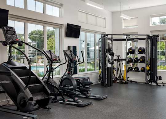 A gym with treadmills, weights, and exercise equipment.