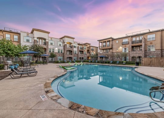 a swimming pool with an apartment building in the background