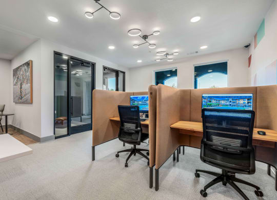 two computer desks and chairs in a room with a large window