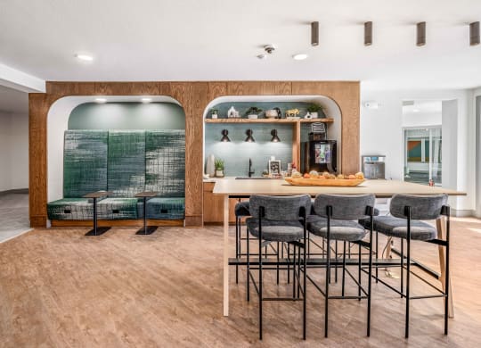 a bar with stools and a counter with chairs in a room with a kitchen