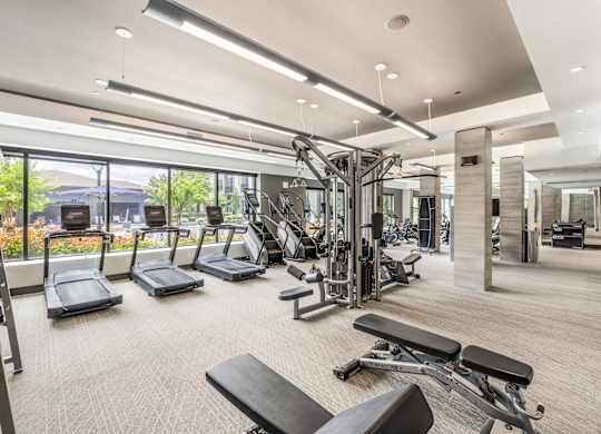 A spacious gym with a variety of equipment and a view of the outdoors.