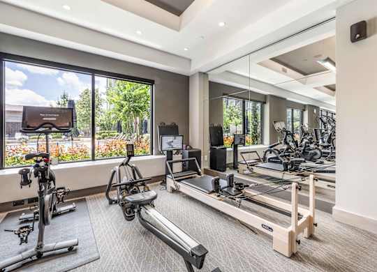 A spacious gym with treadmills, exercise bikes, and a television.