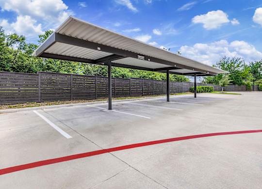 A parking lot with a canopy and red lines on the ground.