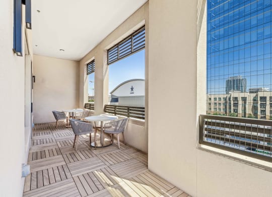 a balcony with tables and chairs and a view of a city