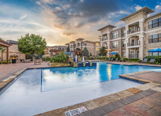 a large swimming pool with an apartment building in the background