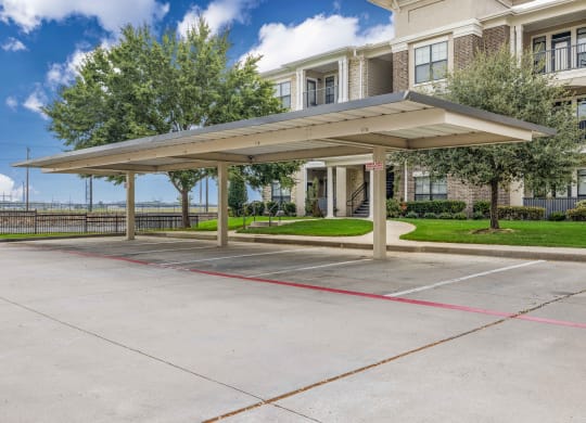 a covered parking lot in front of an apartment building