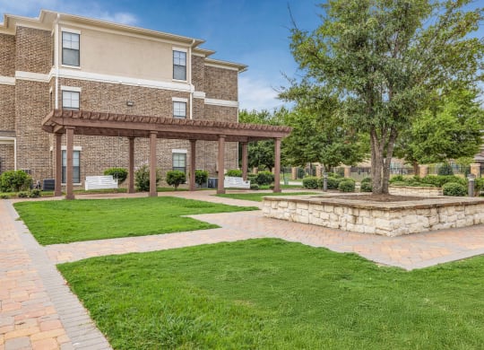 a brick patio with a stone fire pit in front of a building