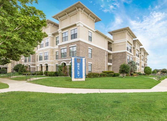 an apartment building with a blue sign in front of it