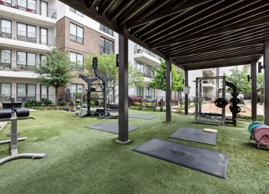 amenities including a fitness center with weights and cardio equipment on the grass