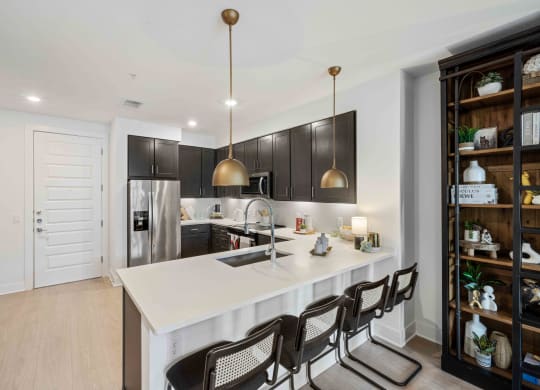 a kitchen with a white counter top and black cabinets