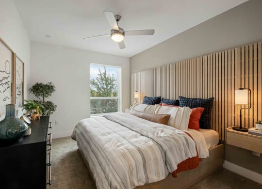 a bedroom with a bed and a ceiling fan