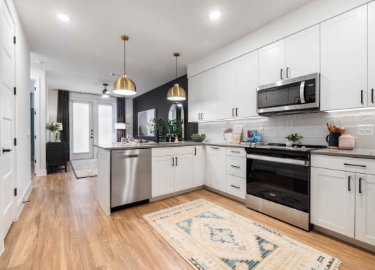 a large kitchen with white cabinets and stainless steel appliances