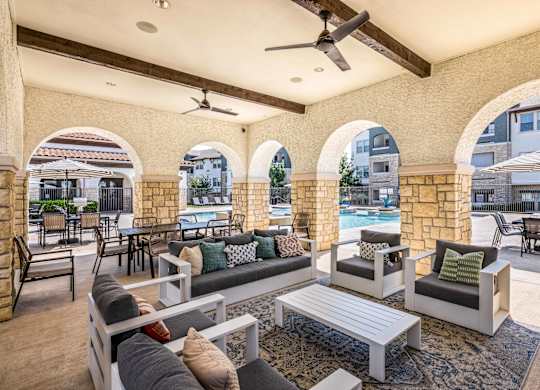 A patio with a pool and a table with chairs.