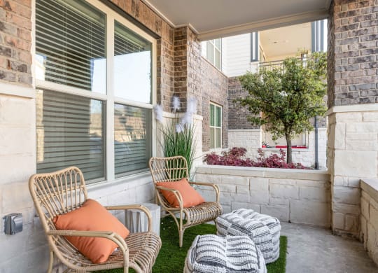 a porch with two chairs and a table and a window