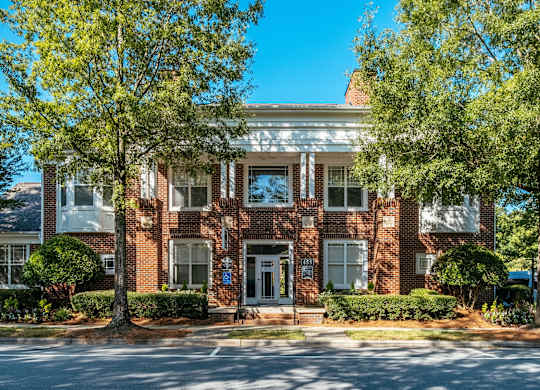 A red brick building with a white door and windows.