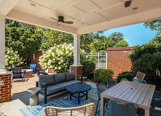 A patio with a table and chairs under a roof.
