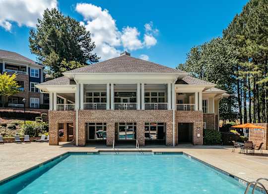 A large building with a pool in front of it.