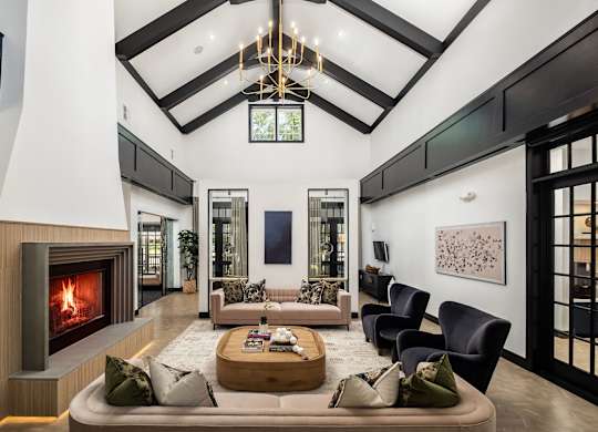 A modern living room with a fireplace and a large painting on the wall.