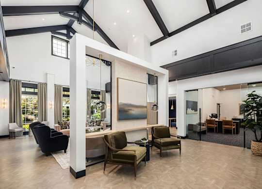 A spacious living room with a large painting on the wall and a variety of seating options.