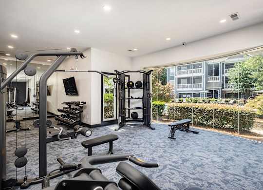 A gym with a variety of equipment including a weight bench, a leg press machine, and a cable machine.