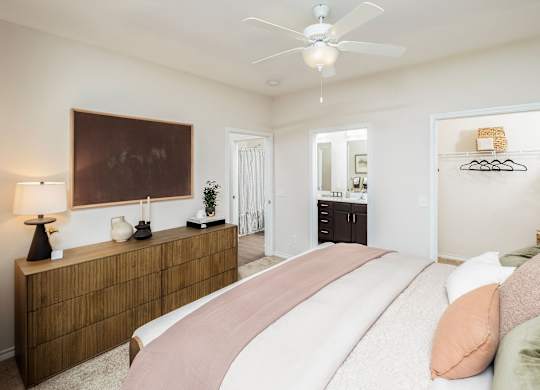 A bedroom with a large bed and a wooden dresser.