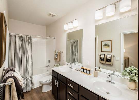 A bathroom with a white sink and a white toilet.
