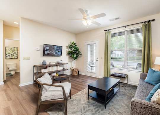 A living room with a couch, chair, and television.